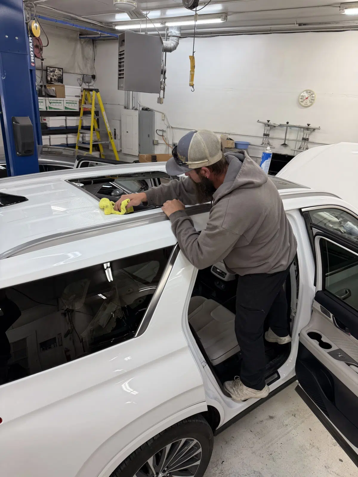 Technician cleaning the roofline of a white SUV interior — A+ Glass LLC in Billings